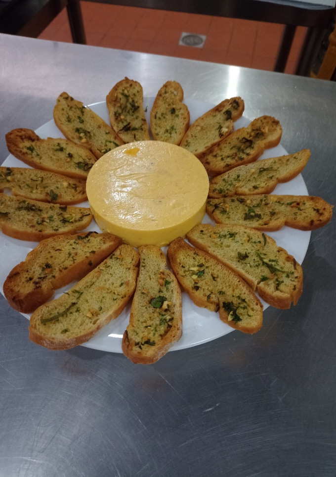 Una foto de Spread moldeado de pejibaye con tostadas de ajos y perejil