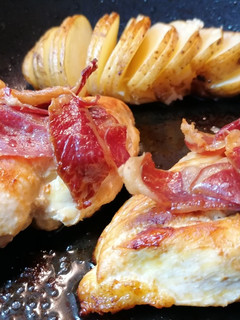 Una foto de Pechugas de pollo al horno con patatas hasselback y jamón