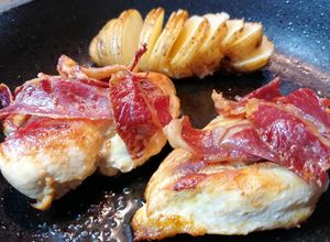 Una foto de Pechugas de pollo al horno con patatas hasselback y jamón