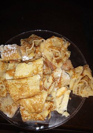 A picture of Pancakes garnished with icing sugar.