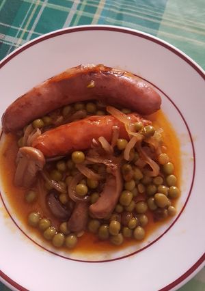 Una foto de Salchichas frescas con champiñones y guisantes