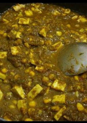 A picture of Palak paneer with sweet corn.