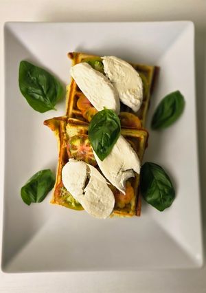 Una foto de Gofres de parmesano con ensalada caprese