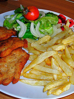 Una foto de Filetes de pechuga de pollo rebozadas con patatas pajas y ensalada