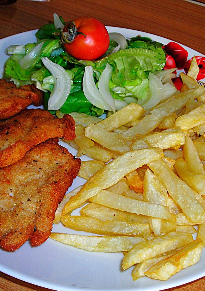 Una foto de Filetes de pechuga de pollo rebozadas con patatas pajas y ensalada