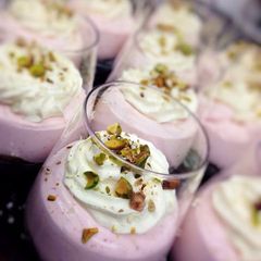 A picture of Strawberries cheese cake with rum whipped cream and pistacchio.