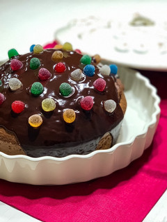 Una foto de Tarta de chocolate y almendras con cobertura de chocolate y gominolas