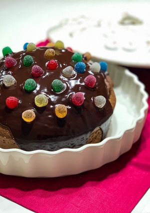 Una foto de Tarta de chocolate y almendras con cobertura de chocolate y gominolas