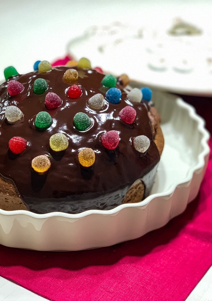Una foto de Tarta de chocolate y almendras con cobertura de chocolate y gominolas