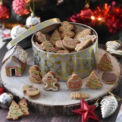 A picture of Stuffed gingerbread cookies & small gingerbread home.