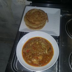 A picture of Naan bread and chicken curry.