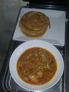 A picture of Naan bread and chicken curry.