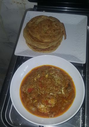 A picture of Naan bread and chicken curry.