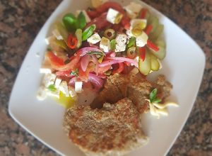 Una foto de Milanesas al horno, con ensalada "mediterránea"