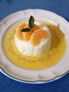 Una foto de Panna cotta de coco con coulis de mandarina y mezcal
