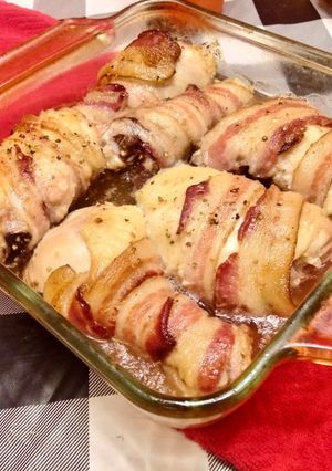 Una foto de Pollo enrollado de tocino encamado en cebollas al horno