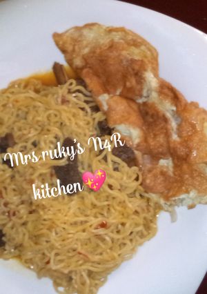 A picture of Indomie noodles with fry eggs.