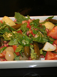 Una foto de Ensalada de granada, canónigos y rúcula
