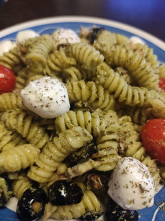Una foto de Ensalada de Fusilli con Pesto Suave, Cherry, Mozzarella, Aceitunas Negras con Piñones y Pistachos