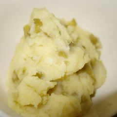 A picture of Mashed potatoes with green beans.