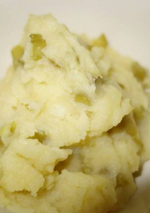 A picture of Mashed potatoes with green beans.