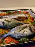 Orata al pompelmo al forno con patate e pomodori