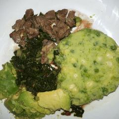 A picture of Mukimo served with goat fry and veges.