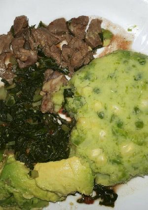 A picture of Mukimo served with goat fry and veges.