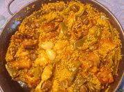 Una foto de arroz con caracoles y pollo