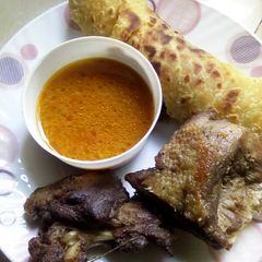 A picture of Deep fried duck served with soup and chapati.