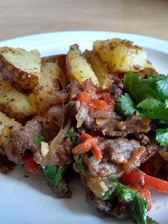 Una foto de Lomo saltado acompañado de papas rústicas