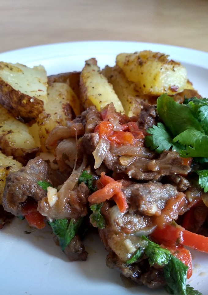 Una foto de Lomo saltado acompañado de papas rústicas