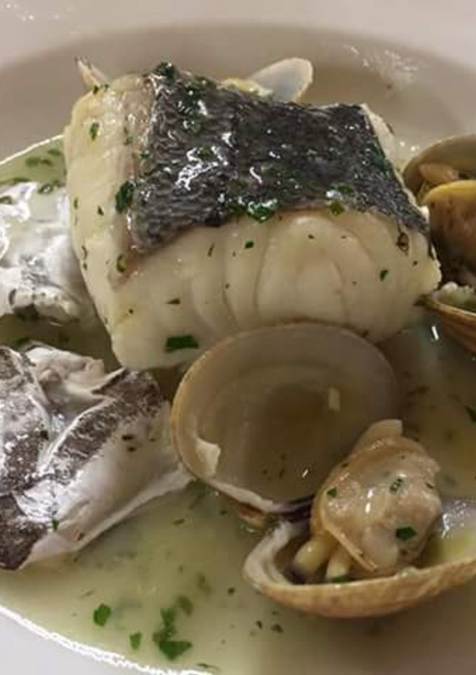 Una foto de Cogote de merluza con cocochas y almejas
