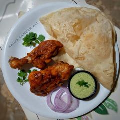 A picture of Steamed chicken tikka with puri paratha.