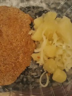 Una foto de Milanesa de pollo con ensalada de papa y cebolla