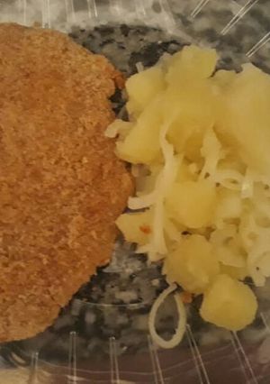 Una foto de Milanesa de pollo con ensalada de papa y cebolla