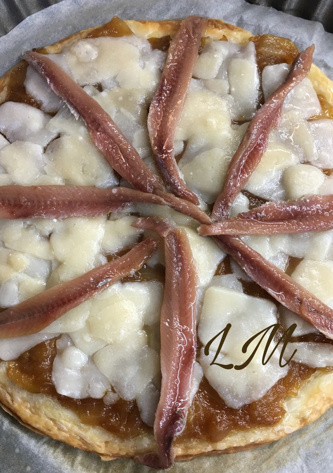 Una foto de Tosta de hojaldre con cebolla caramelizada, queso parmesano y anchoas