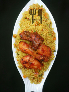 A picture of Vegetable jollof rice with ppe chicken.