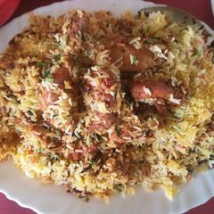 A picture of Chicken tikka biryani with boondi raita.