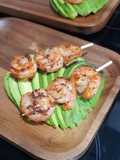 Brocheta de camarones sobre palta