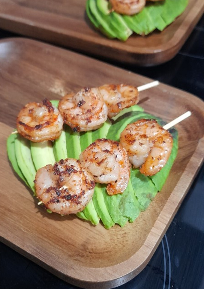 Una foto de Brocheta de camarones sobre palta