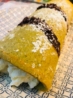 Una foto de Brazo de té Matcha con nata y chocolate negro