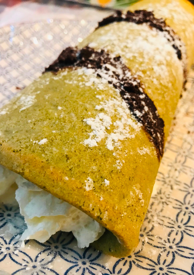 Una foto de Brazo de té Matcha con nata y chocolate negro