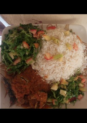 A picture of Rice and Stew with fish and salad.