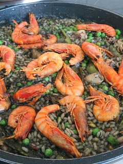 Una foto de Arroz negro con gamba roja y tirabeques