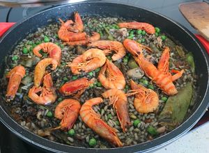 Una foto de Arroz negro con gamba roja y tirabeques