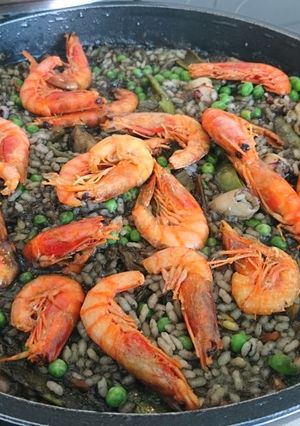Una foto de Arroz negro con gamba roja y tirabeques
