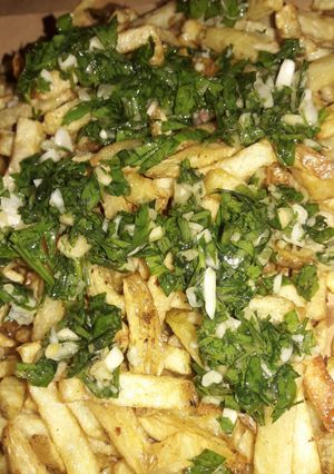 Una foto de Papas fritas con perejil y ajo