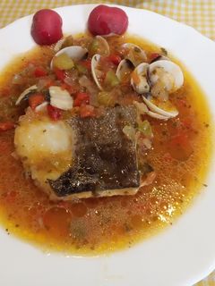 Una foto de Lomos de Bacalao con tomate pimientos y almejas