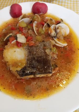 Una foto de Lomos de Bacalao con tomate pimientos y almejas